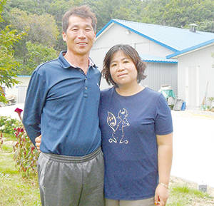 강원도가 아름다운 농장으로 선정한 다솜농장 무창계사 앞에서 안기춘·송명숙 대표 부부가 포즈를 잡았다.