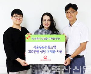 서울우유 홍보실 변성인 팀장(오른쪽)이 네쌍둥이 홍광기·김정화 부부에게 300만원 지원 기증서를 전달하고 있다.