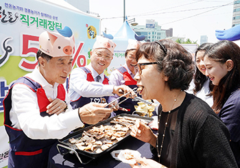 왼쪽부터 한돈자조금 하태식 위원장, 한국농축산연합회 임영호 회장, 나눔축산운동본부 안승일 사무총장이 시민들에게 한돈삼겹살을 제공하고 있다.