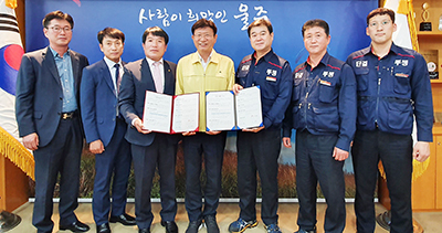 왼쪽 세 번째부터 윤주보 조합장, 이선호 군수, 이성훈 노조위원장이 협약서에 서명한 후 기념촬영을 하고 있다.