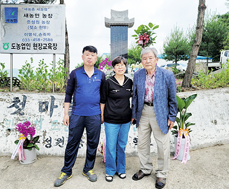 준성원목장 입구에 세워진 효부비 앞에서 (왼쪽부터)남편 이석현·이금자 공동대표, 시아버지 이명식 회장이 함께 기념촬영을 하고 있다.