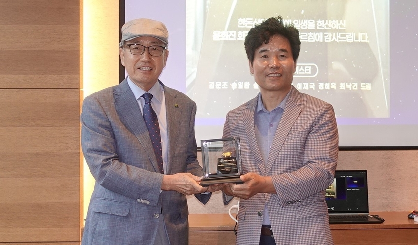 윤희진 회장(왼쪽)이 송일환 대표에게 감사패를 전달받고 있다