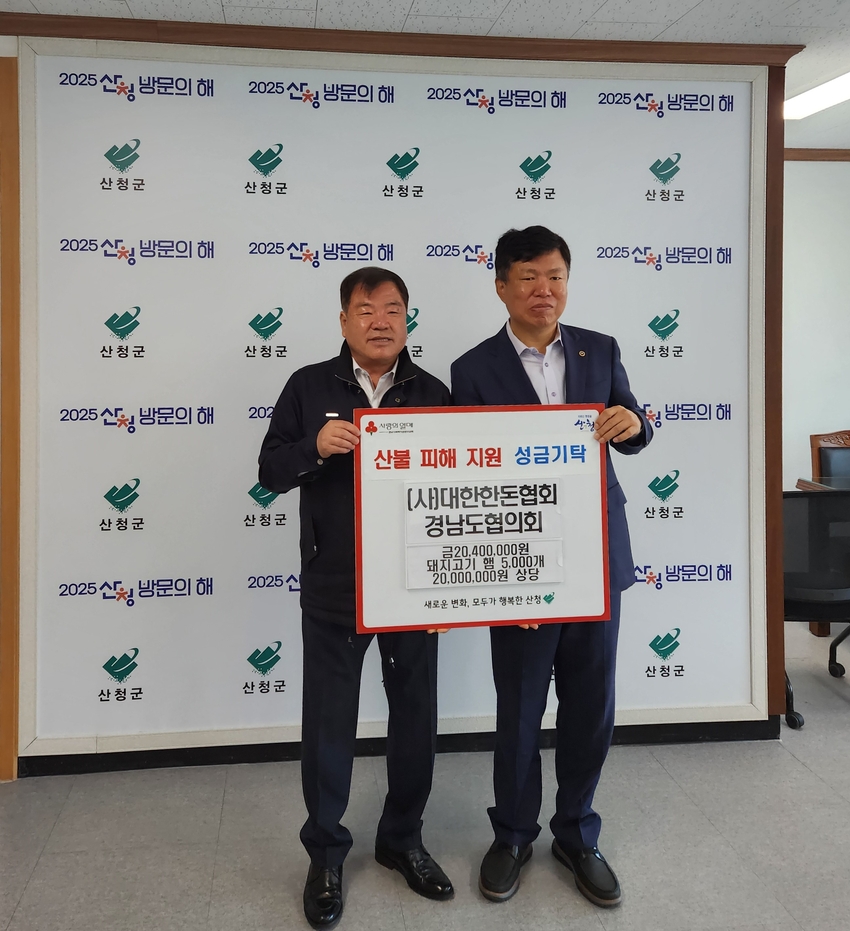 주재용 한돈협회 경남도협의회장(오른쪽)이 산청군에 기탁금을 전달하고 있다.