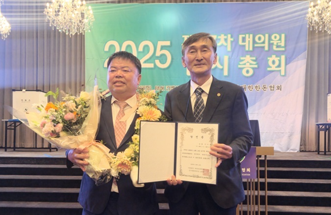 조영욱 선거관리위원장이 이기홍 후보(왼쪽)에게 당선증을 전달한 후 기념촬영을 하고 있다