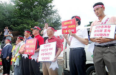 지난 21일 한국양계TS 부화장에서 열린 산란계 농가 집회에서 안영기 대한양계협회 채란분과위원장(윗줄 마이크 든 이)이 부화장의 실용계 사업 진출 철회를 요구하고 있다.