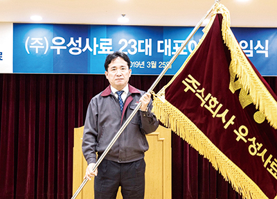 한재규 대표이사가 취임식을 마치고 우성사료 깃발을 받아 들었다.