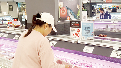 한 소비자가 대형마트에서 판매되고 있는 990원 삼겹살을 꼼꼼히 살피고 있다.