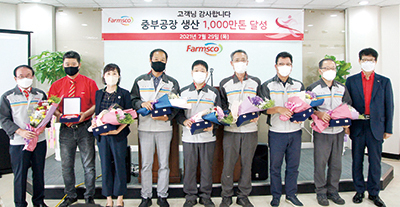 정학상 총괄사장(오른쪽)과 안윤식 사료생산본부장(왼쪽)이 1천만톤 달성의 주역들과 기념촬영을 하고 있다.